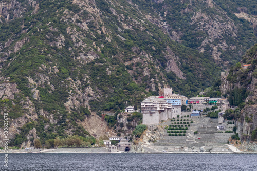 Scenic view from boat on Tower of Dionysios Monastery at Mount Athos, Chalkidiki, Central Macedonia, Greece, Europe. Eastern Orthodox terrain of Again Oros. Landmark build on coastline rock formation photo