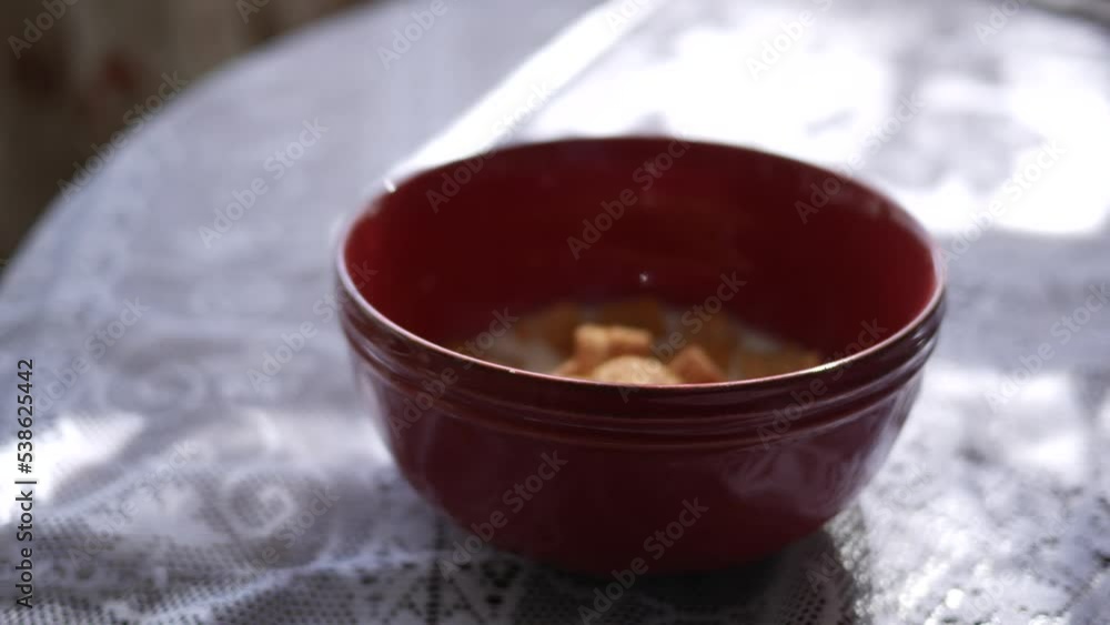 Pouring sugar cinnamon cereal into a bowl with milk Pouring sugar cinnamon cereal into a bowl with milk