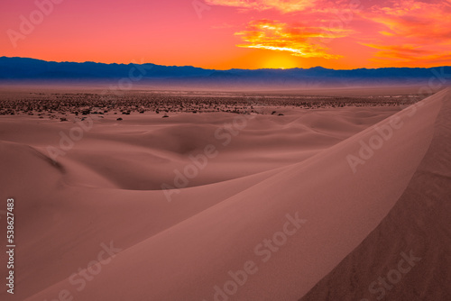 Fototapeta Naklejka Na Ścianę i Meble -  Mesquite Flat Sand Dunes and abstract geometry of curving arid desert terrain at pink sunset in Death Valley National Park, California