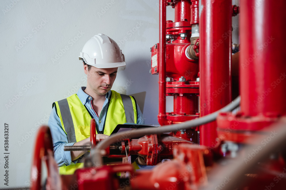 Engineers inspecting the inside plumbing and water valves of an industrial facility. Engineers inspecting the inside plumbing and water valves of an industrial facility.