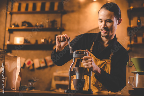 barista holding hand grinde...