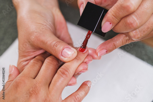 Woman Painting Nails And Enjoying Manicure Treatment At A Beauty Salon