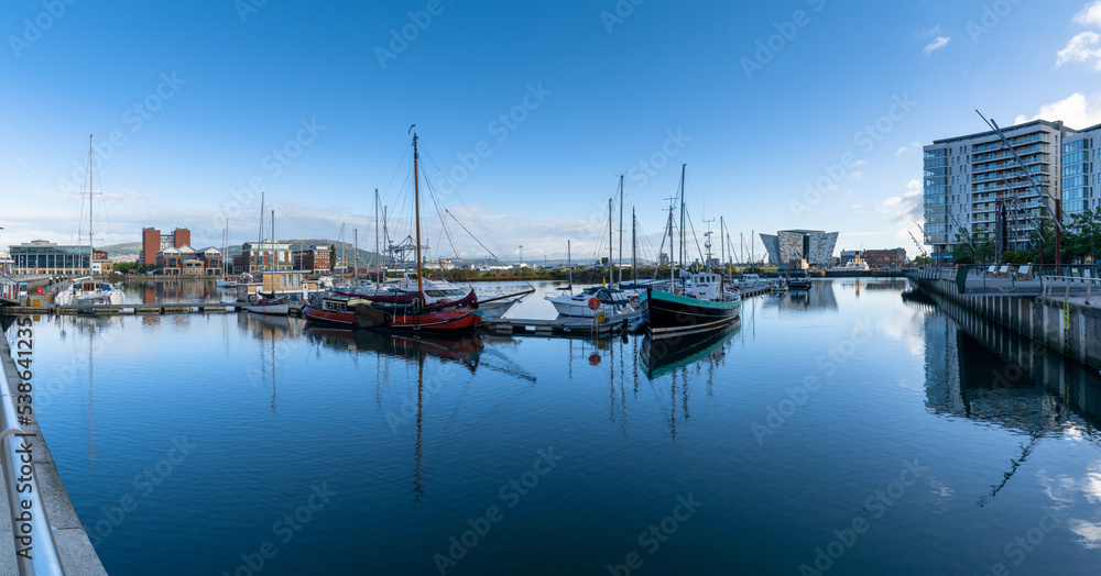 boats moored in the harbor in the Titanic Quarter of Belfast on the River Lagan with the Titanic Museum in the background