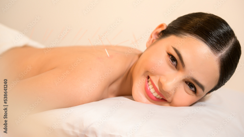 Beautiful Woman Received acupuncture treatment on back by therapist, chinese medicine treatment, health and healing concept. Beautiful Woman Received acupuncture treatment on back by therapist, chinese medicine treatment, health and healing concept.