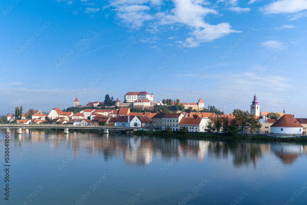 panorama cityscape of Ptuj with the hilltop castle and reflections in the Drava River