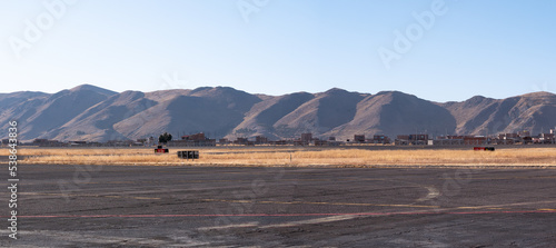 Airstrip with a View of the Mountains, the Dry and Yellow Soil in Contrast to a Beautiful Clear Blue Sky