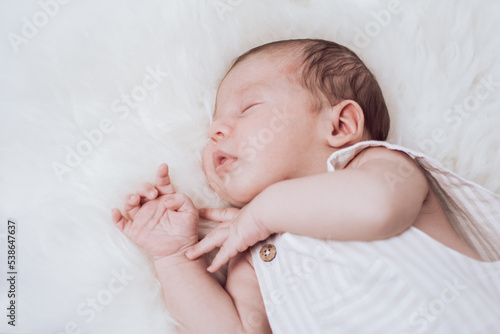 portrait of a sleeping baby lying on a fur