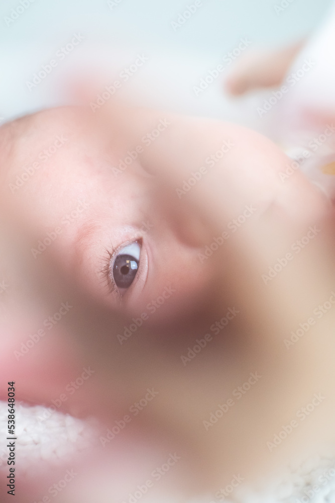 portrait baby looking through hand, focus on eye portrait baby looking through hand, focus on eye