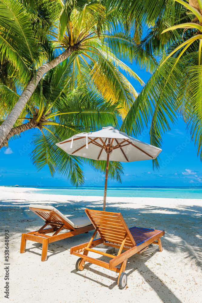 Beautiful tropical island, couple beds umbrella under palm tree leaves, paradise sea sand sky. Summer travel landscape amazing vacation beach. Idyllic exotic nature closeup of recreation relaxation.