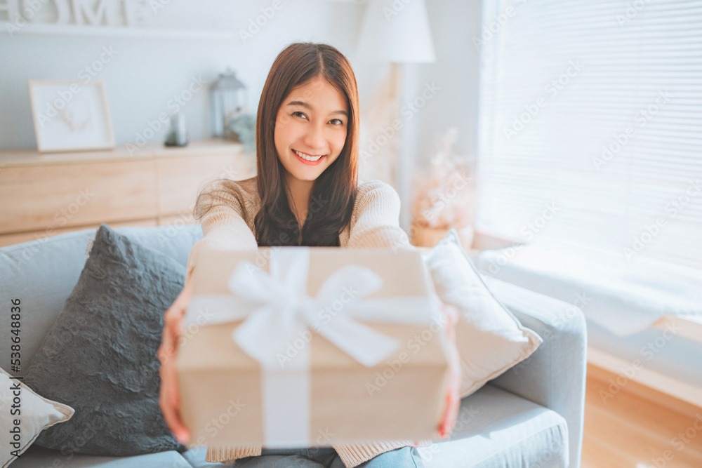 Happy smile asian woman holding a gift box in a gesture of giving, Gives a gift, Anniversary, Birthday gift. Happy smile asian woman holding a gift box in a gesture of giving, Gives a gift, Anniversary, Birthday gift.