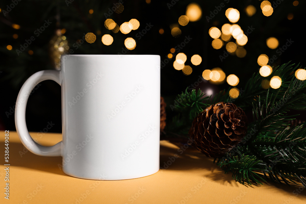 White ceramic mug with blank copy space for text and logo on a dark background with Christmas defocus lights. White ceramic mug with blank copy space for text and logo on a dark background with Christmas defocus lights.