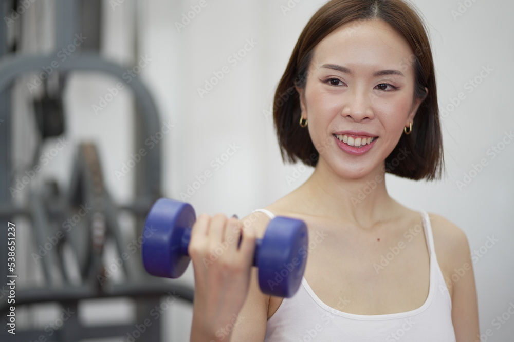 Asian Sports women in gym.Portrait of fitness young woman in sports clothing exercising on cardio machine at gym. Asian Sports women in gym.Portrait of fitness young woman in sports clothing exercising on cardio machine at gym.
