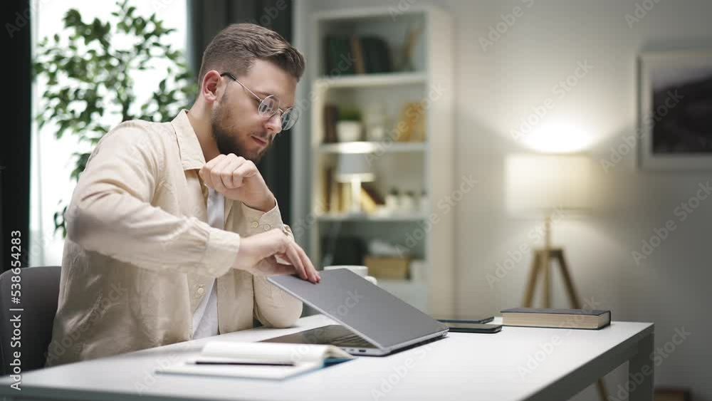Young caucasian male freelancer working at home, closing laptop and smiling, successful day Young caucasian male freelancer working at home, closing laptop and smiling, successful day