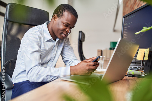 Distracted employee looking using mobile phone while working at office