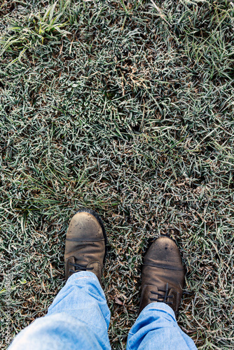 Man stepping over frost on grass, dawn light (ID: 538658834)