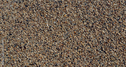 Texture of coarse sea sand close-up, small pebbles. For design, background, postcards, collages and compositions
