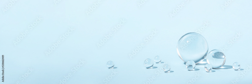 Blue background with transparent glass balls. Minimal concept and soft sunlight. Blue background with transparent glass balls. Minimal concept and soft sunlight.