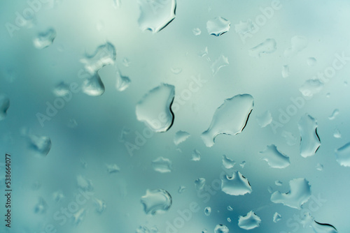 Water drops on glass against blue sky. Window view background screensaver. Place for text banner.