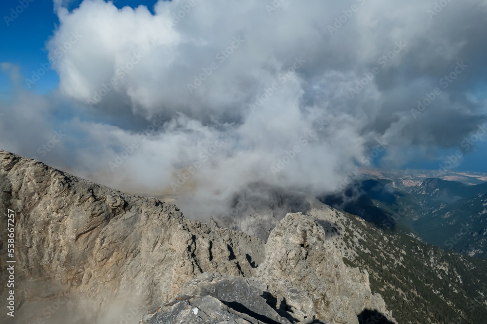 Panoramic view from cloud covered mountain summit of Mytikas Mount Olympus, Mt Olympus National Park, Macedonia, Greece, Europe. Home of the Ancient Greek gods. Hiking trail from Skala and Stefani Panoramic view from cloud covered mountain summit of Mytikas Mount Olympus, Mt Olympus National Park, Macedonia, Greece, Europe. Home of the Ancient Greek gods. Hiking trail from Skala and Stefani
