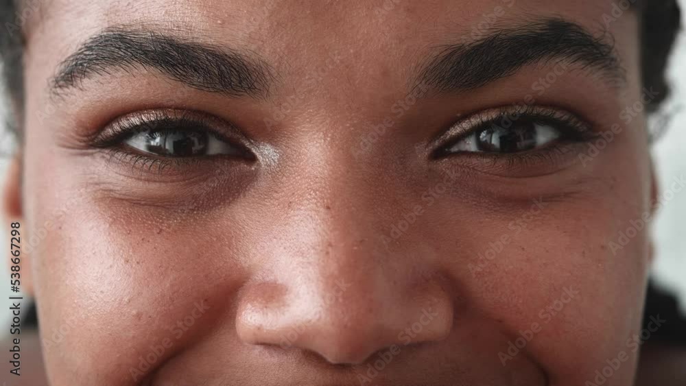 Cropped view of a face portrait of a young multiethnic woman cutely smiling looking at the camera. Focus on female eyes expressing positive emotions happiness. Close-up. Headshot. Cropped view of a face portrait of a young multiethnic woman cutely smiling looking at the camera. Focus on female eyes expressing positive emotions happiness. Close-up. Headshot.