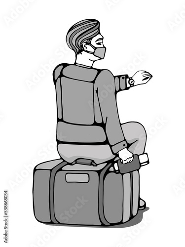 A man traveler in a mask looks at his watch sitting on a suitcase with a ticket.