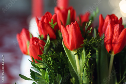 Multiple red tulips in a closeup. Tulip bouquet indoors. Flower that can symbolize love, Christmas, Easter or even Netherlands. Bright colorful spring season flowers blooming. Color image.