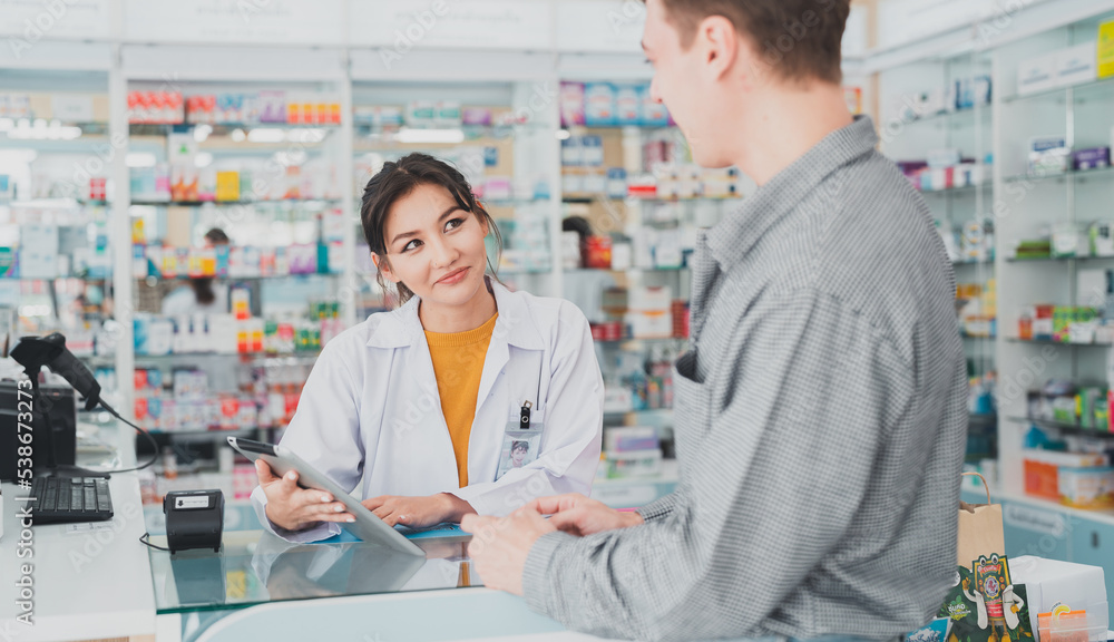 Business, pharmacy, professional health care.Female pharmacist with medical expertise.A female doctor stands to recommend health care pills to male customers at a pharmacy.