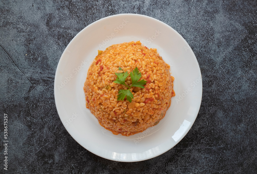 Traditional turkish bulgur pilaf with tomato sause in plate (Turkish name; meyhane pilavi)