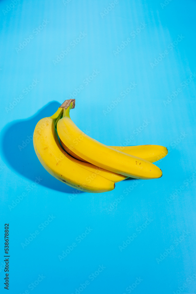 Yellow bananas isolated on light blue background, High potassium food Yellow bananas isolated on light blue background, High potassium food