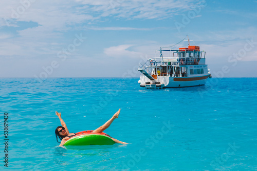 sexy woman swimming in blue sea on inflatable ring