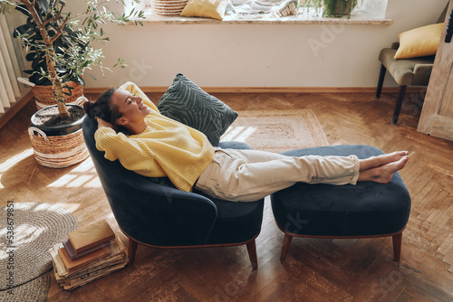 Valokuva Top view of happy woman keeping eyes closed while relaxing in comfortable chair