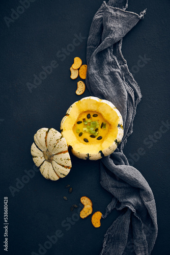 Pumpkin cream soup served in squash with seeds
