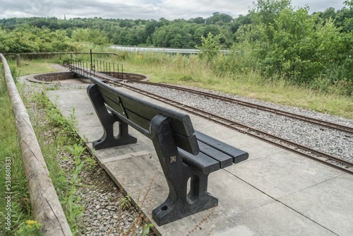 Trentham Gardens Park Bench Against Miniature Railway Sunny Day photo