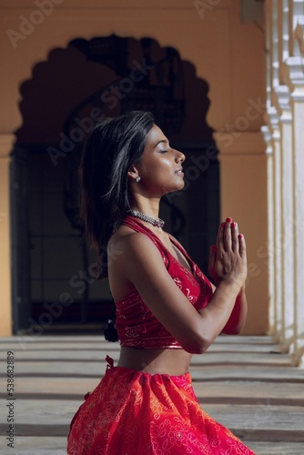 Vertical shot of an Indian yogini in among white columns photo