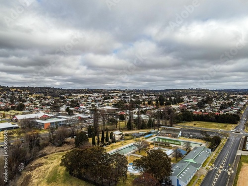 Aerial shot of country town buildings, main street, dry trees and the skyline in Armidale, Australia photo