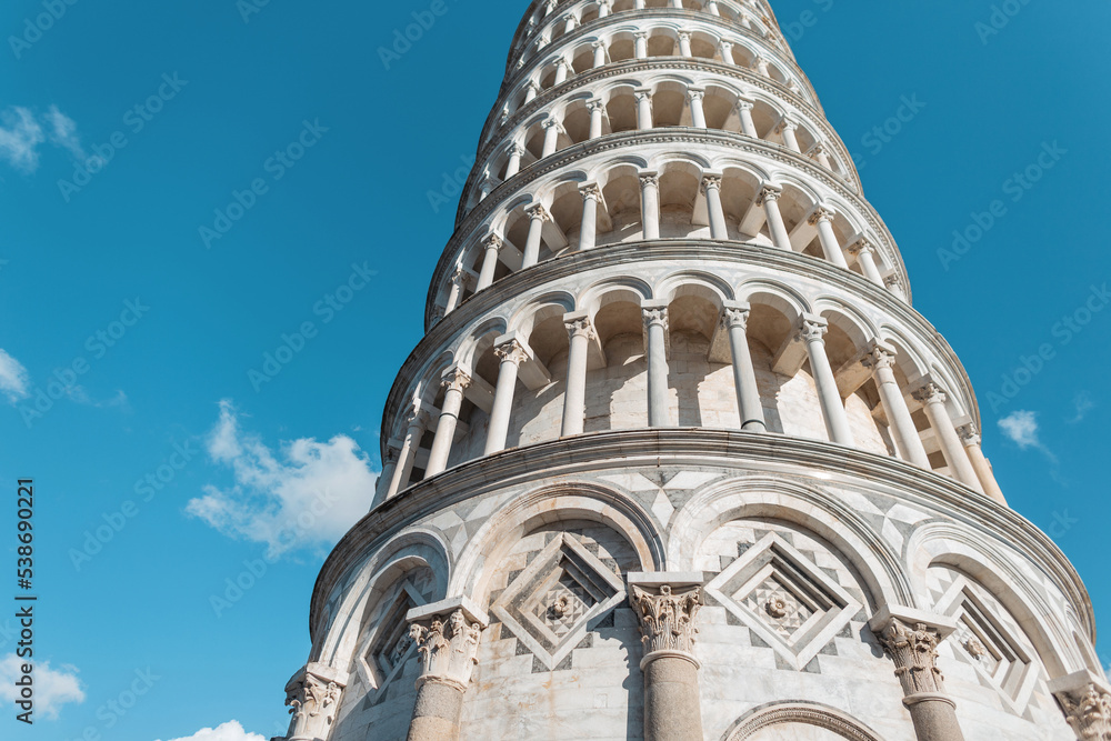 Amazing Romanesque architecture of the tower with columns on a blue sky background in the European city of Pisa, Italy