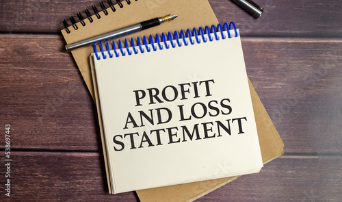 profit and loss statement words on white notebook and wooden background