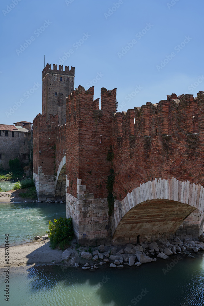 View of the Castel Vecchio Bridge (or Scaliger Bridge) connected to Castelvecchio Castle along Adige river in Verona, Italy - July, 2022