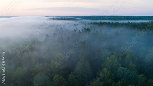 Summer dawn over foggy forest and river aerial drone view. Aerial panoramic landscape with sunset over the river and beautiful clouds on the sky.