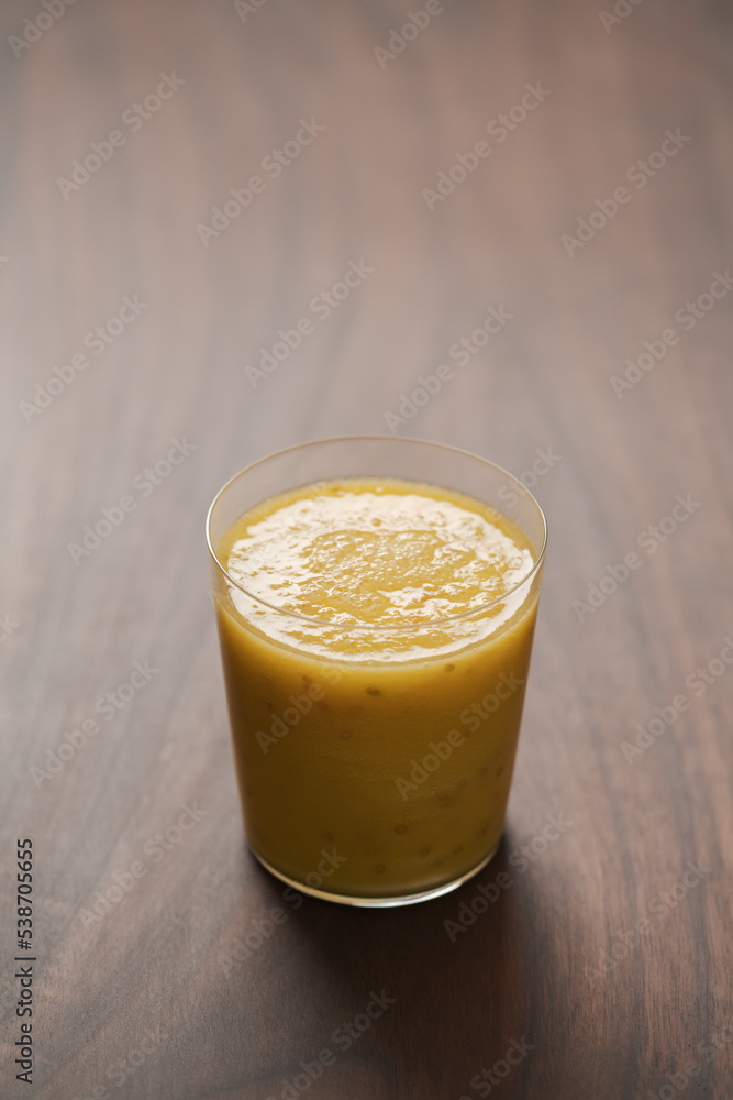 Mango lulo smoothie on walnut wood table with copy space Mango lulo smoothie on walnut wood table with copy space