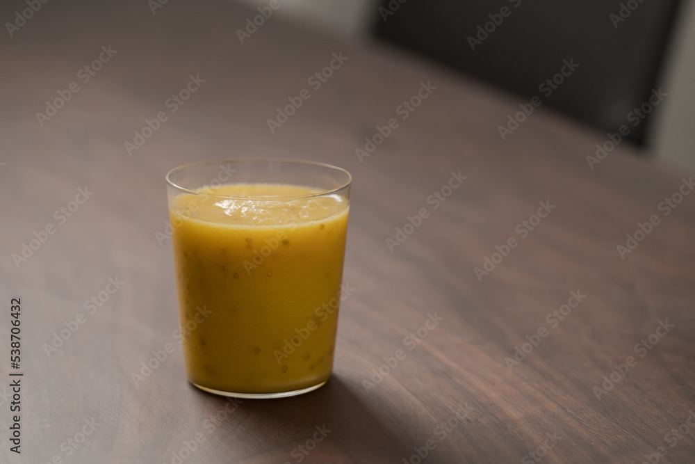 Mango lulo smoothie on walnut wood table with copy space Mango lulo smoothie on walnut wood table with copy space