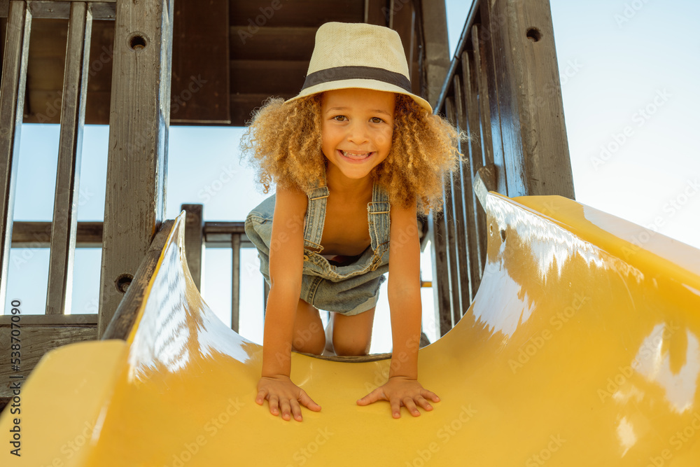 Φωτογραφία Happy Little child girl sliding and playing at outdoor playground in the park on summer vacation