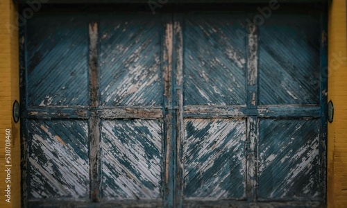 Old blue wooden gate inside a yellow brick frame
