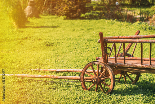 Gardening And Housekeeping. Vintage Cart On Summer Sunny Day. Decorative Peasant Cart On Summer Lawn. Bright Sunny Day. Garden Decoration Concept. Garden Wagon. Copy Space. photo