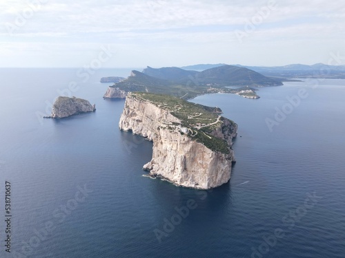 Aerial view of Capo Caccia's vertical cliffs surrounded by the clear blue sea photo