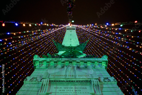A low angle view of a monument in Indianapolis that is strung with Christmas lights to create a giant Christmas tree.