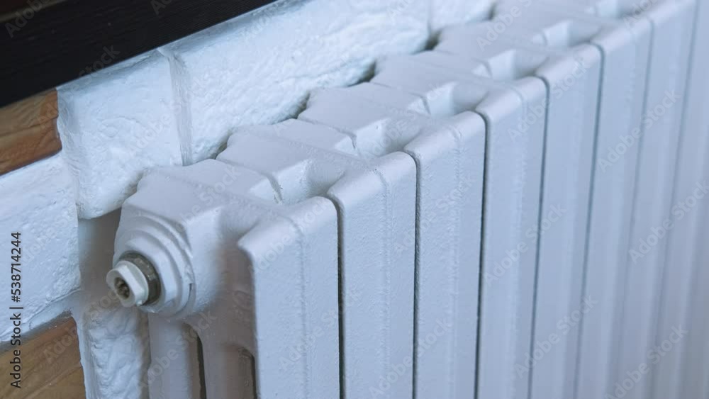 Rise prices for heating in winter. A woman puts money on cold radiator in apartment. A concept of rising prices for heating during European crisis and world crisis. Rise prices for heating in winter. A woman puts money on cold radiator in apartment. A concept of rising prices for heating during European crisis and world crisis.
