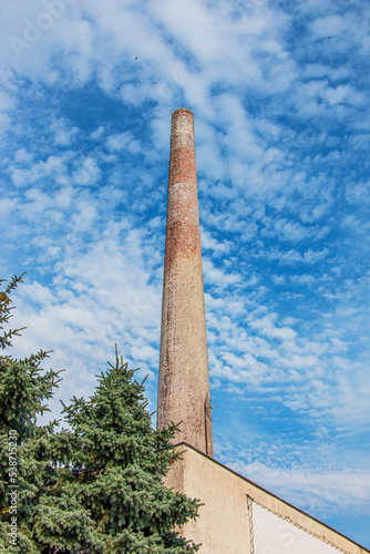 The pipe of a gas boiler house against the blue sky. No smoke comes out of the chimney. Energy crisis.