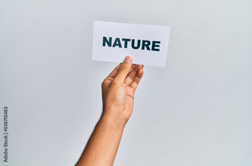 Hand of caucasian man holding paper with nature word over isolated white background Hand of caucasian man holding paper with nature word over isolated white background