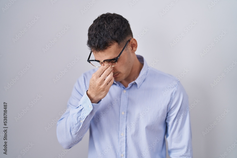 Handsome hispanic man wearing business clothes and glasses tired rubbing nose and eyes feeling fatigue and headache. stress and frustration concept. Handsome hispanic man wearing business clothes and glasses tired rubbing nose and eyes feeling fatigue and headache. stress and frustration concept.